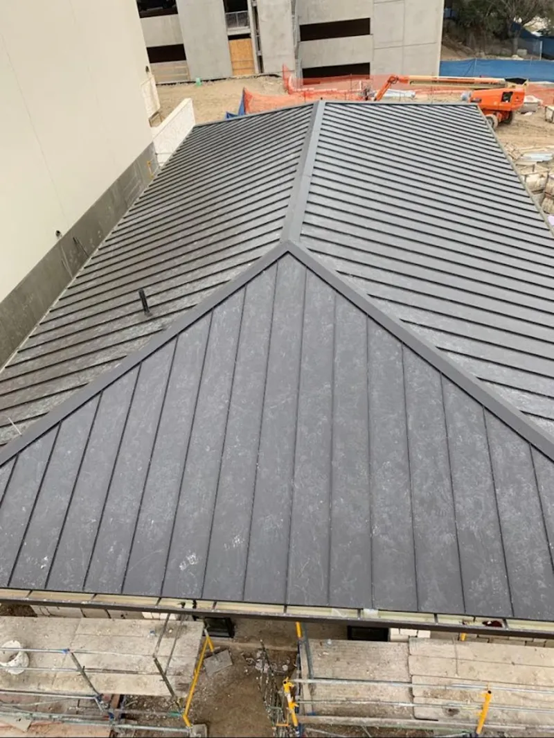 Commercial metal roof construction with crane equipment in Kettering